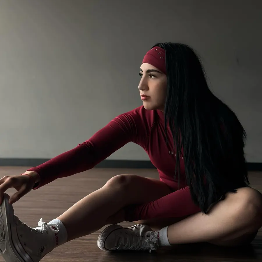 Conjunto rojo de manga larga estirando en el suelo